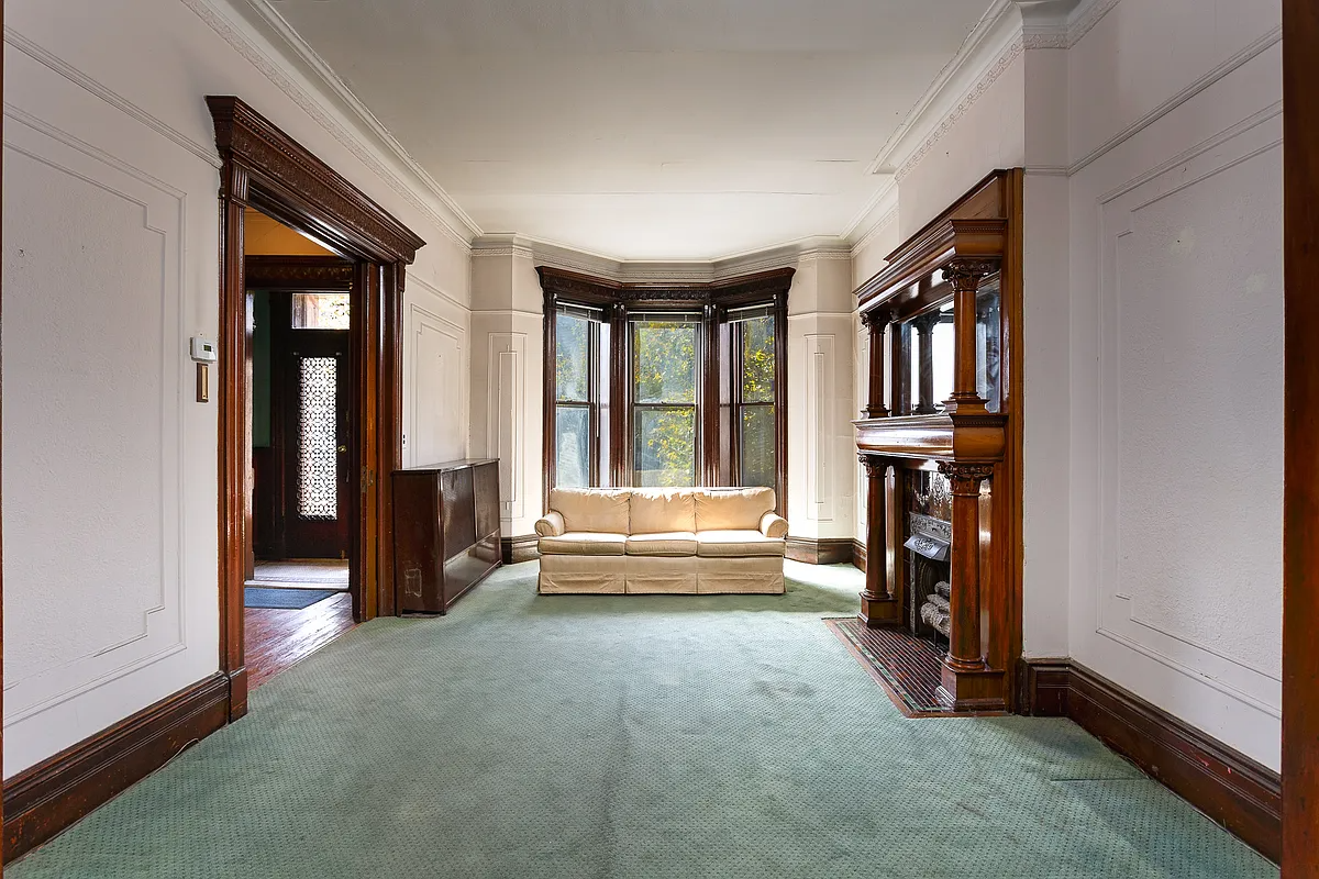 parlor with a mantel and a green carpet