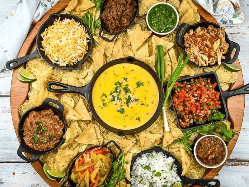 A platter of nachos with different toppings.